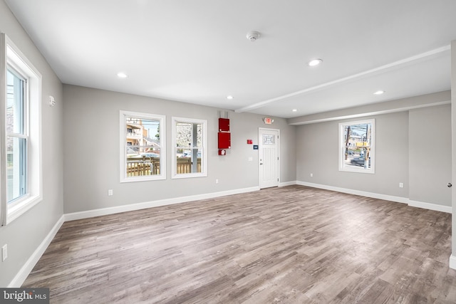 unfurnished living room featuring wood finished floors, baseboards, and recessed lighting