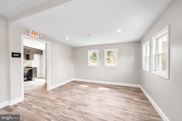 spare room featuring light wood finished floors, baseboards, and recessed lighting