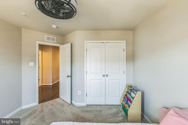 bedroom with baseboards, visible vents, a closet, and carpet flooring