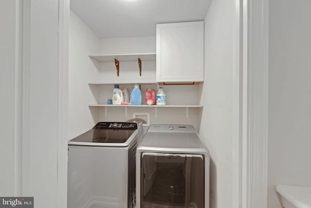 washroom featuring cabinet space and washer and clothes dryer