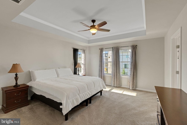 bedroom with baseboards, a tray ceiling, carpet, and ornamental molding