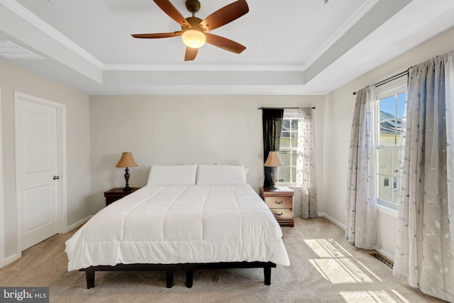 bedroom featuring ornamental molding, light colored carpet, and a raised ceiling