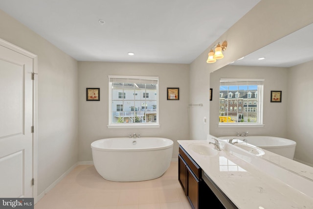 full bath with tile patterned floors, recessed lighting, a freestanding tub, and vanity