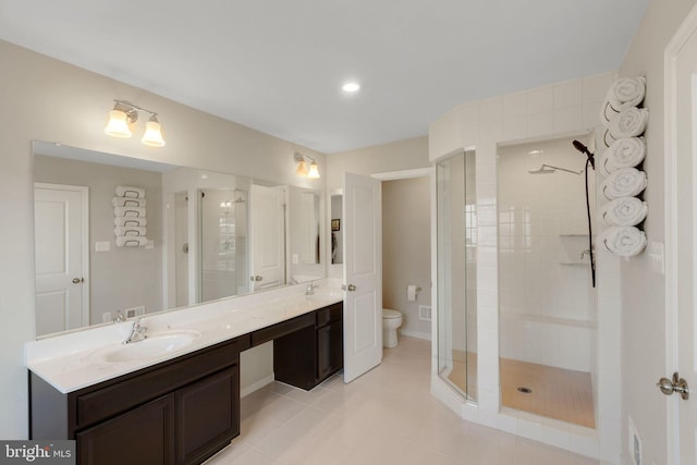 bathroom with tile patterned flooring, toilet, a sink, a stall shower, and double vanity