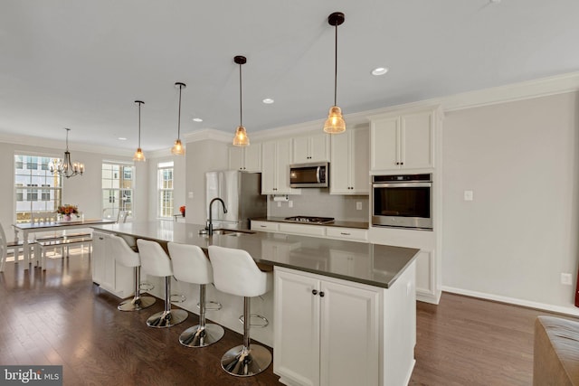 kitchen featuring a sink, ornamental molding, dark wood-type flooring, and stainless steel appliances