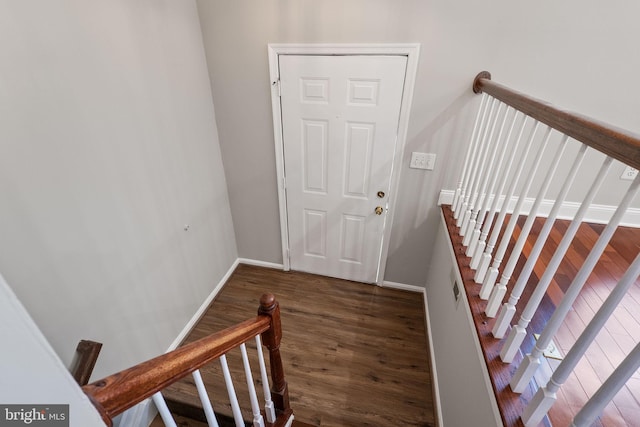 stairway featuring baseboards and wood finished floors