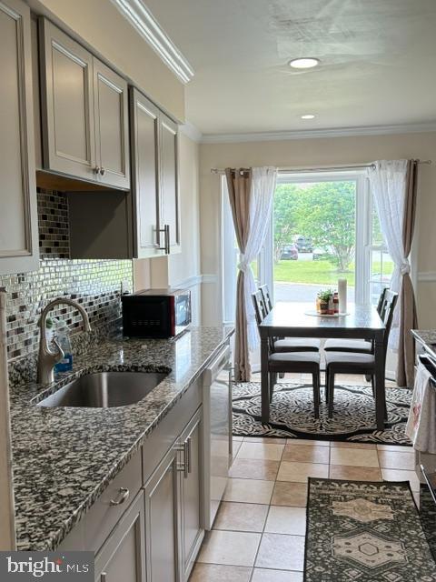 8659 Point Of Woods Dr, Manassas, VA 20110 - kitchen featuring a sink, black microwave, dishwasher, crown molding, and backsplash