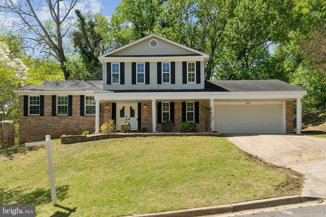 908 Queens Ter, Fort Washington, MD 20744 - view of front facade featuring a front lawn, concrete driveway, a porch, brick siding, and a garage