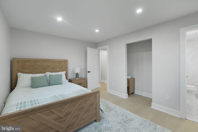 bedroom with recessed lighting, ensuite bathroom, light wood-type flooring, and baseboards