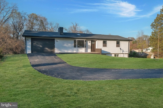 ranch-style home featuring an attached garage, a chimney, aphalt driveway, and a front yard