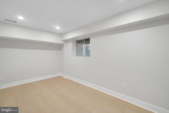 basement featuring light wood-type flooring, baseboards, visible vents, and recessed lighting