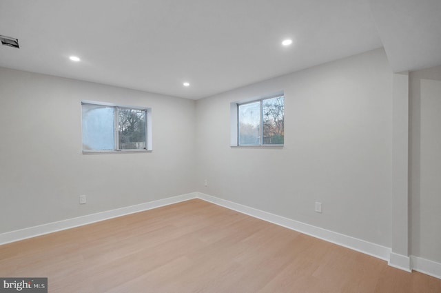 below grade area with light wood-style flooring, baseboards, visible vents, and recessed lighting