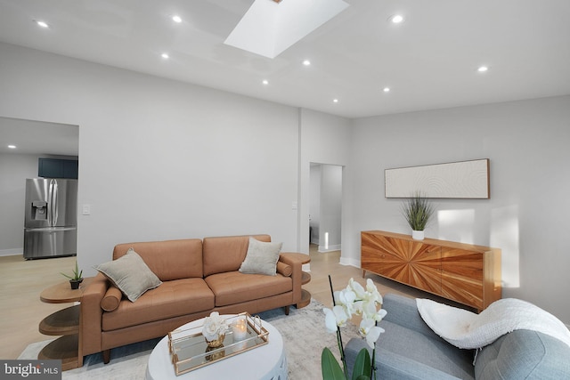 living area with a skylight, recessed lighting, light wood-style floors, and baseboards