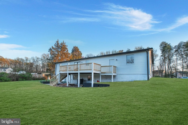rear view of house with a yard, stairway, and a deck