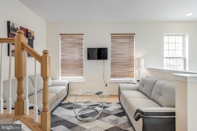 living area featuring light wood finished floors, baseboards, stairs, and recessed lighting