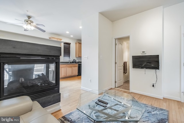 living area with recessed lighting, light wood finished floors, baseboards, and ceiling fan