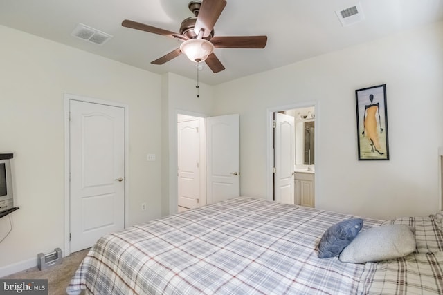 bedroom with visible vents, ensuite bathroom, carpet, and a ceiling fan