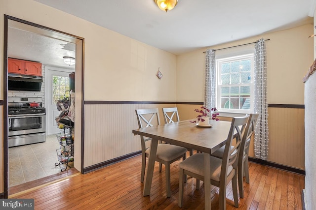 9056 Baltimore St, Savage, MD 20763 - dining space featuring light wood-style flooring, a textured ceiling, and wainscoting