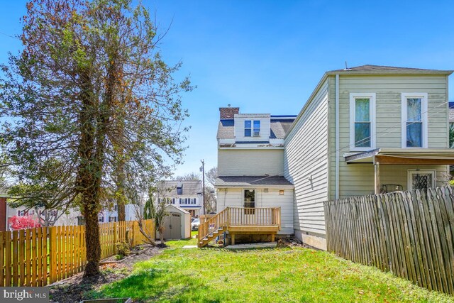 9056 Baltimore St, Savage, MD 20763 - rear view of property with an outbuilding, a storage shed, fence private yard, a lawn, and a chimney