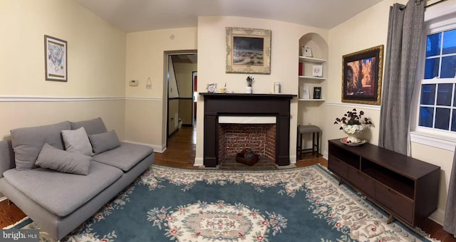 9056 Baltimore St, Savage, MD 20763 - living room featuring built in features, baseboards, wood finished floors, and a fireplace with flush hearth