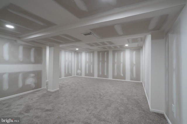 finished below grade area featuring visible vents, baseboards, and carpet floors