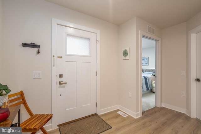 entryway with visible vents, light wood-type flooring, and baseboards