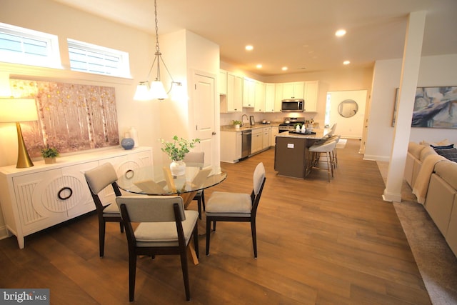 dining area with recessed lighting, dark wood finished floors, baseboards, and an inviting chandelier