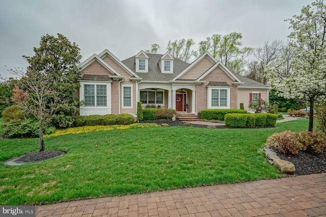 craftsman house featuring brick siding, a front lawn, and covered porch