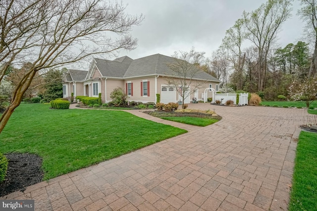 view of front of house featuring a gate, fence, a front lawn, an attached garage, and decorative driveway