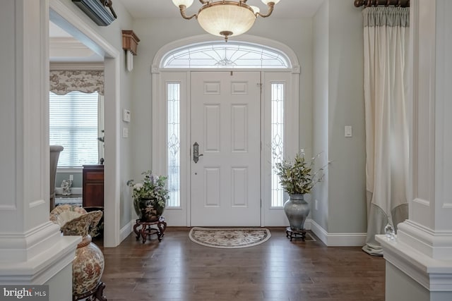 foyer with baseboards, a healthy amount of sunlight, a chandelier, and dark wood-style flooring