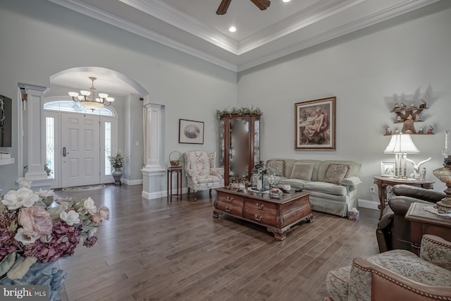 living area with baseboards, arched walkways, wood finished floors, and ornate columns