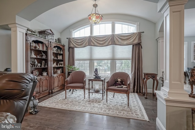 sitting room with arched walkways, dark wood finished floors, lofted ceiling, and decorative columns