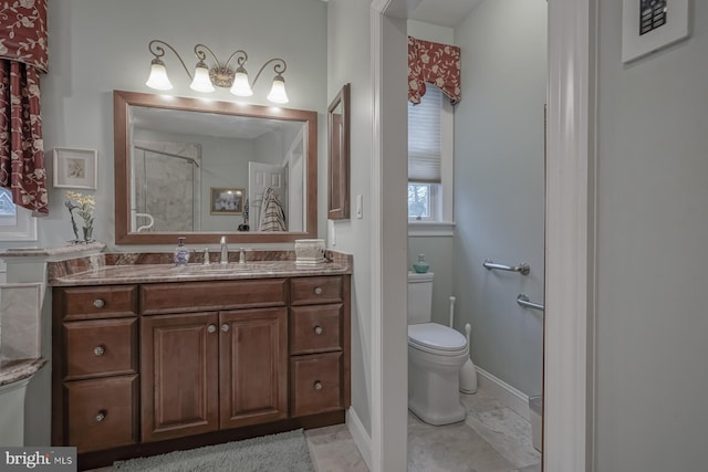 bathroom with toilet, walk in shower, vanity, and baseboards