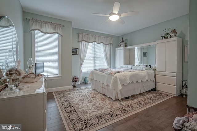 bedroom with dark wood finished floors, ceiling fan, and multiple windows