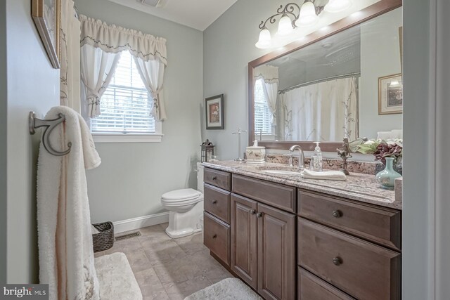 bathroom featuring curtained shower, visible vents, toilet, vanity, and baseboards