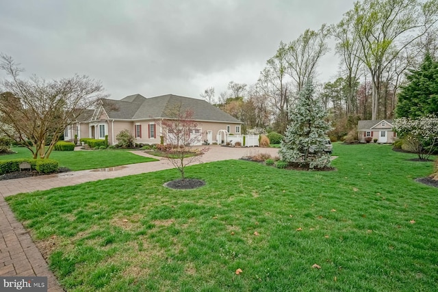 view of yard featuring driveway and an outbuilding
