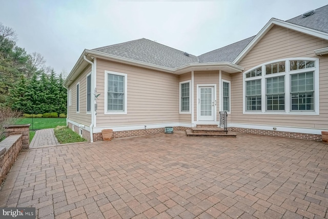 rear view of property featuring a patio area, roof with shingles, and entry steps
