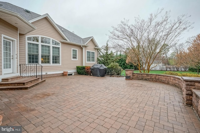 view of patio with fence and a grill
