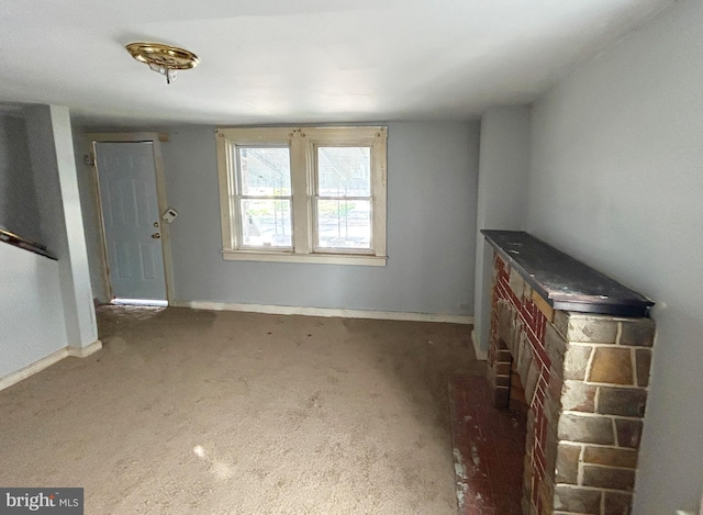 unfurnished living room with baseboards and carpet floors