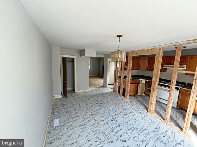 unfurnished dining area featuring visible vents, baseboards, and an inviting chandelier