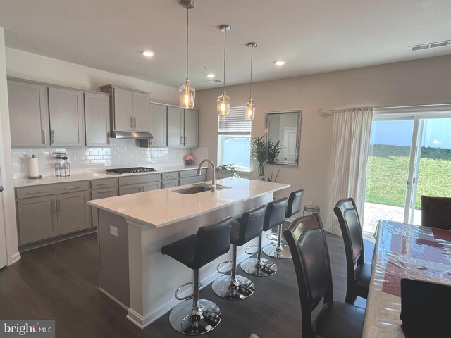 5740 Stone School Ln, Frederick, MD 21704 - kitchen featuring a sink, gray cabinets, decorative backsplash, and a kitchen breakfast bar