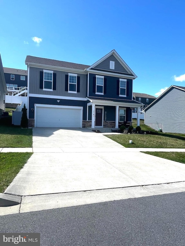 5740 Stone School Ln, Frederick, MD 21704 - view of front of home with concrete driveway, stone siding, a front yard, a porch, and a garage