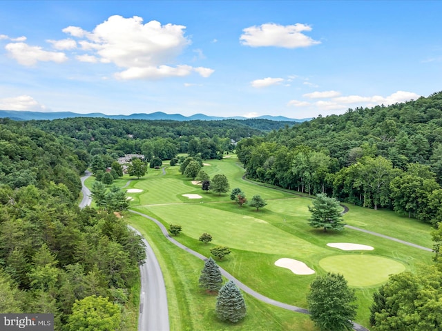 birds eye view of property with golf course view, a wooded view, and a mountain view
