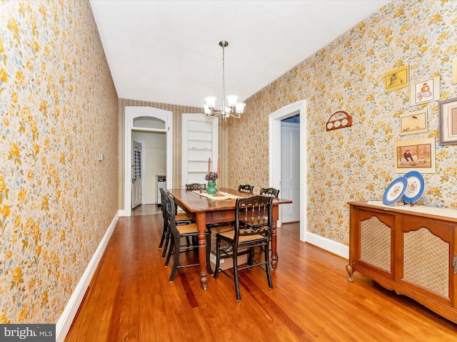 36 Fulton Ave, Walkersville, MD 21793 - dining room with wallpapered walls, wood finished floors, arched walkways, and an inviting chandelier