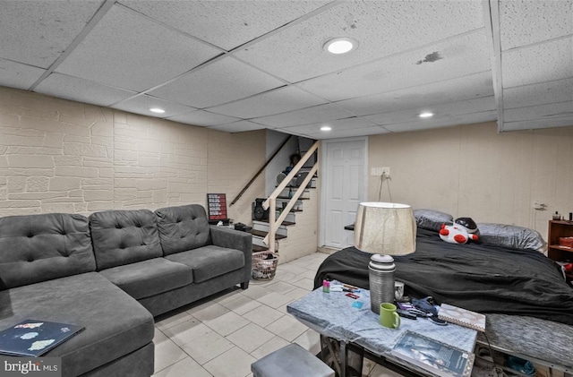 living area featuring stairway, a drop ceiling, and recessed lighting