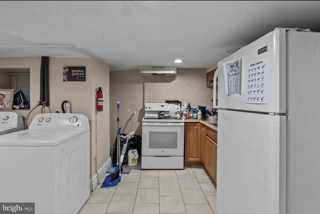 kitchen featuring light tile patterned floors, exhaust hood, white appliances, independent washer and dryer, and brown cabinetry