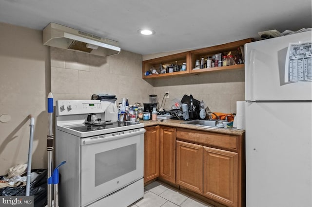 kitchen with light tile patterned floors, white appliances, under cabinet range hood, light countertops, and a sink