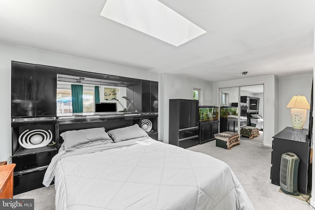 bedroom featuring a skylight, a closet, and carpet flooring