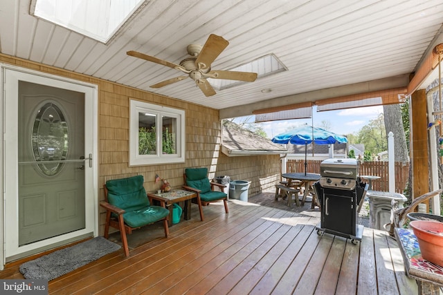 wooden deck featuring a ceiling fan, outdoor dining area, a grill, and fence
