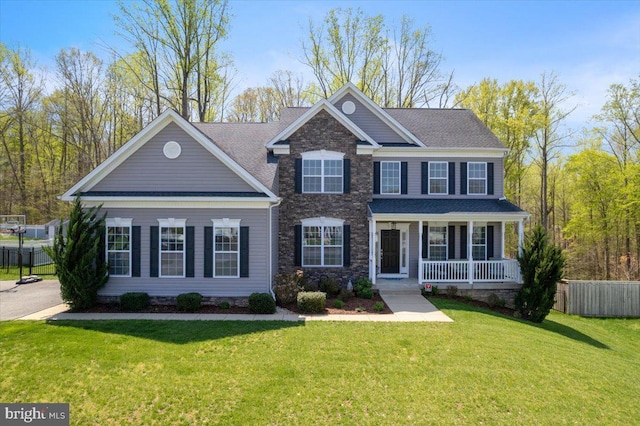 1230 Fairwood Dr, Huntingtown, MD 20639 - view of front of property with fence, roof with shingles, a front lawn, stone siding, and covered porch